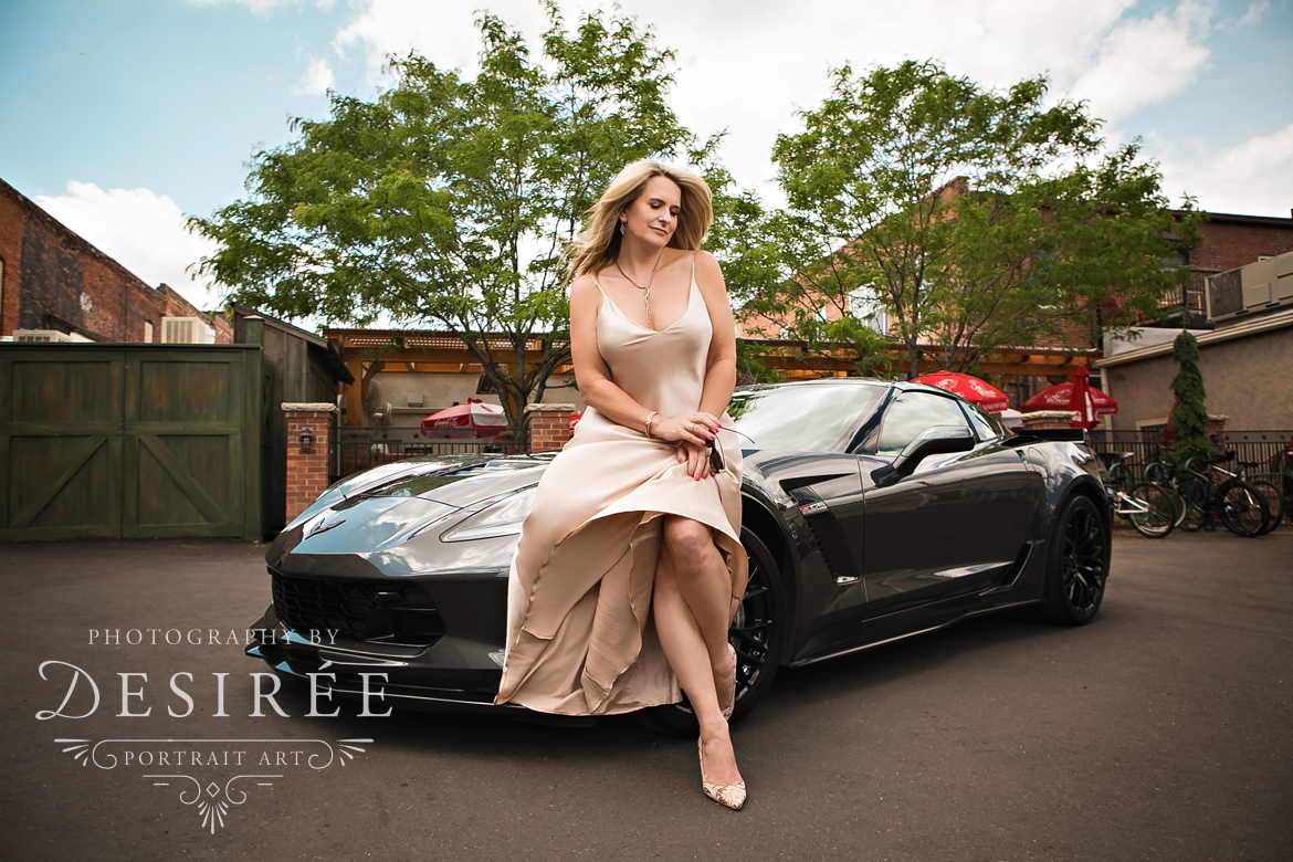 beautiful woman in silky dress sitting on a corvette (fort collins boudoir photographer)