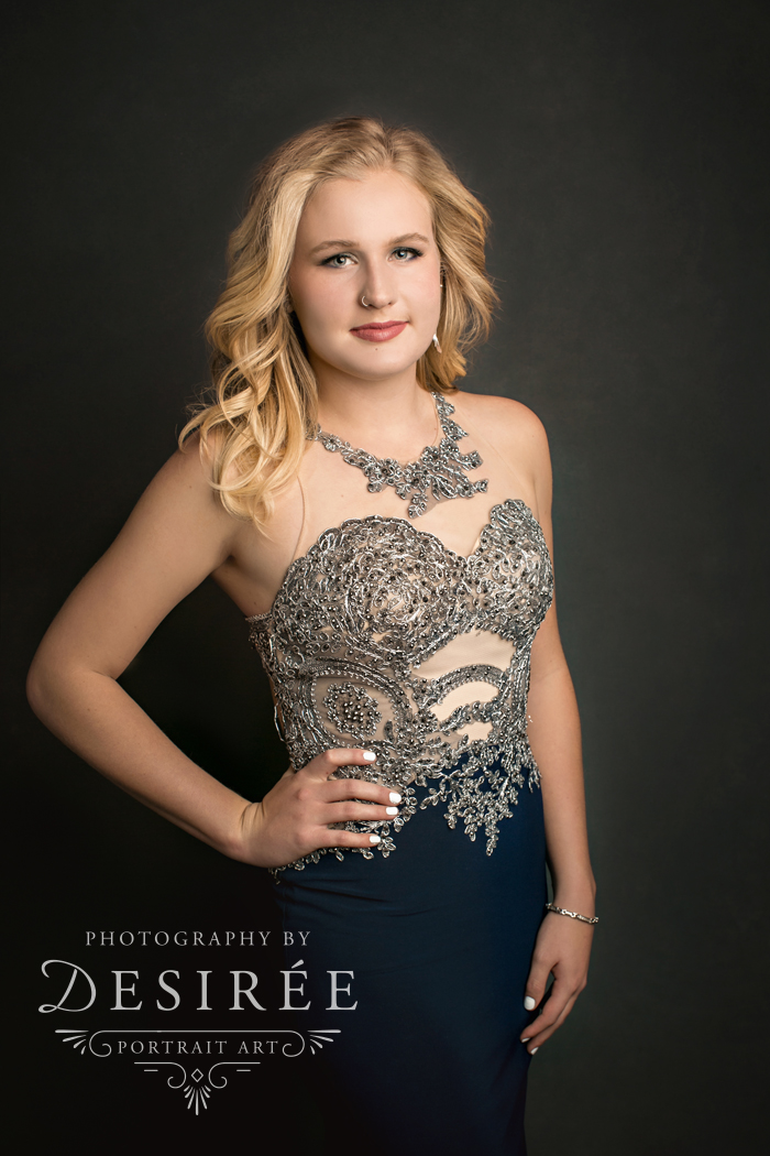 serious studio portrait of blonde girl wearing a beaded gown