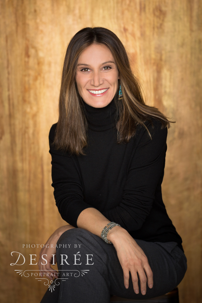 business portrait of a smiling woman against a gold backdrop