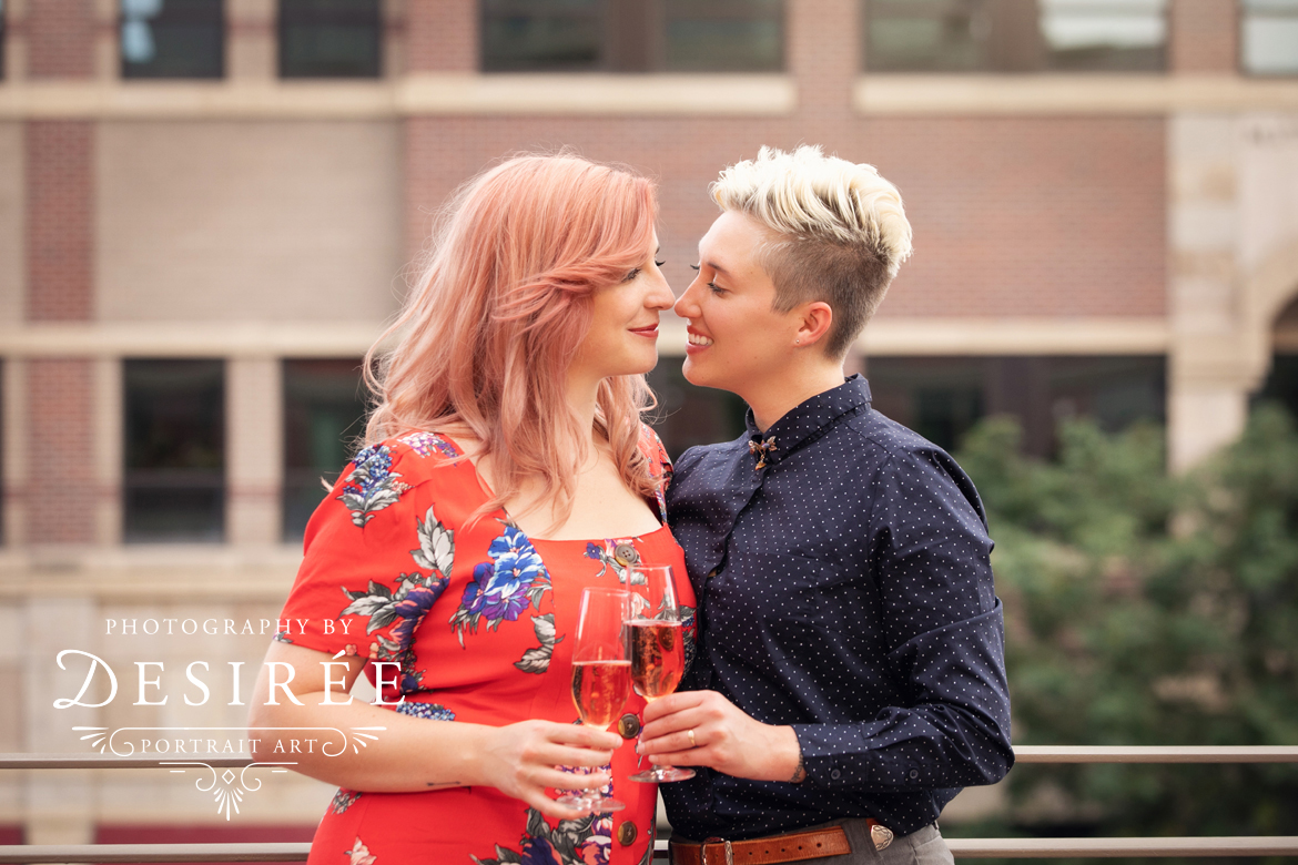 beautiful couple looking at each other almost touching noses and smiling with glasses of champagne on a terrace