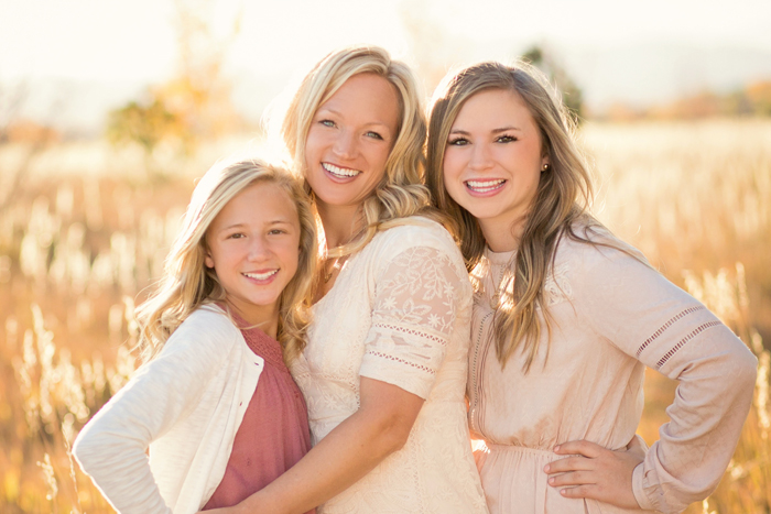 dreamy backlit image of mother and two daughters in golden hour