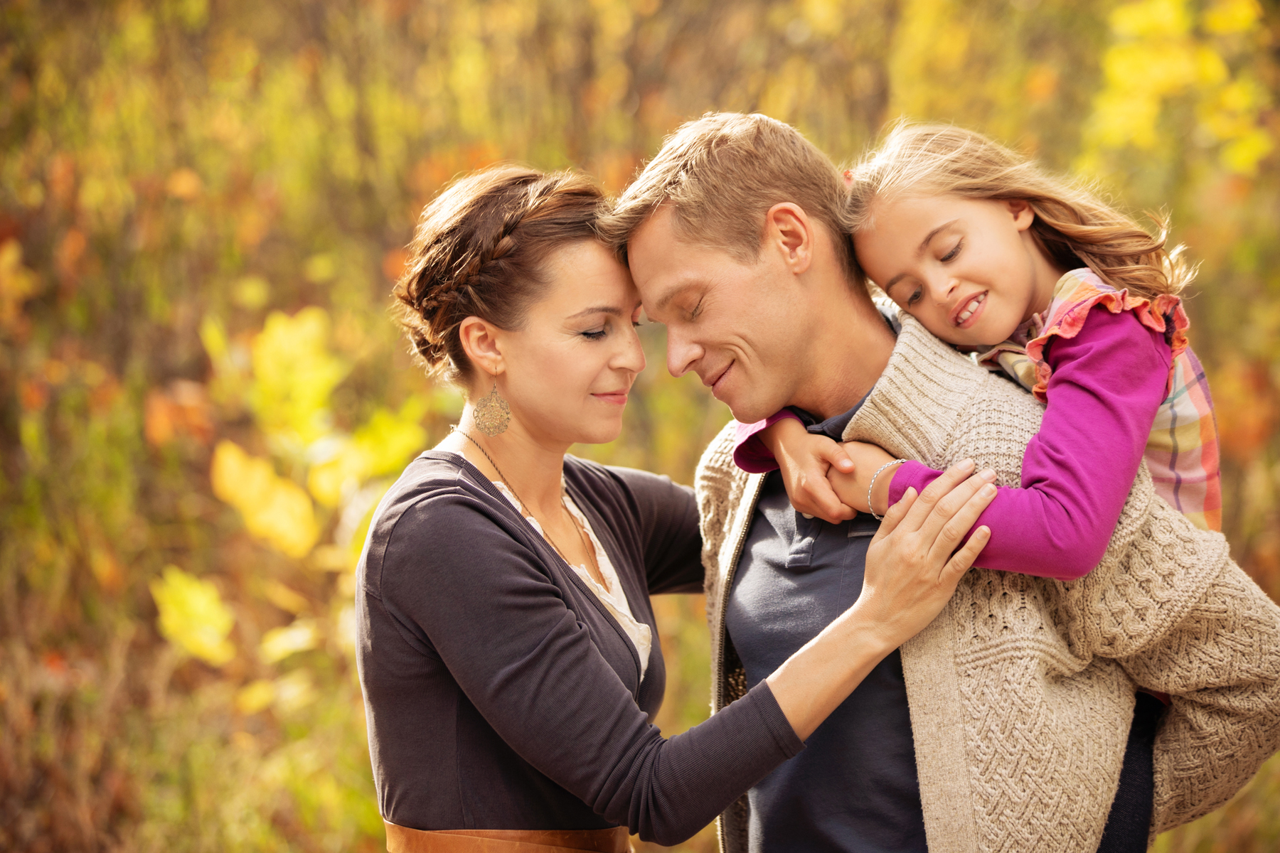 fall photo of family cuddled in front of magical golden background