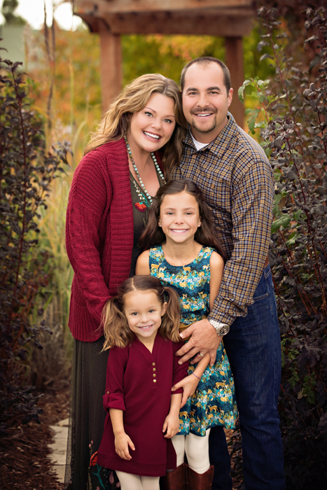 family of four with two beautiful young girls in fall foliage