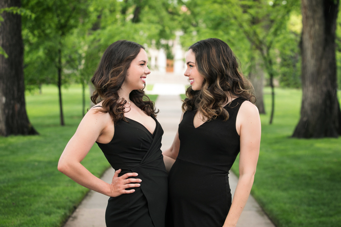 twin college grads looking at each other in CSU oval