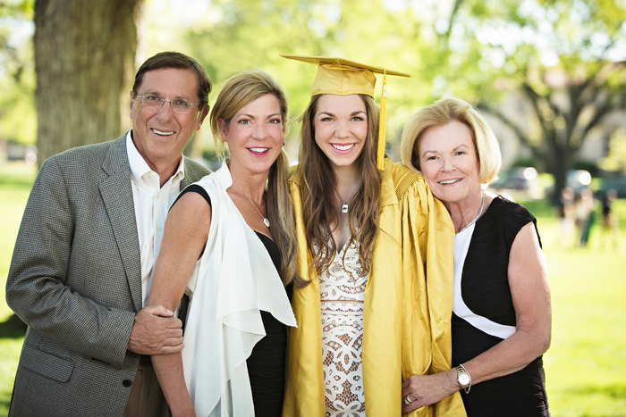 a college grad and her mom and grandparents smiling