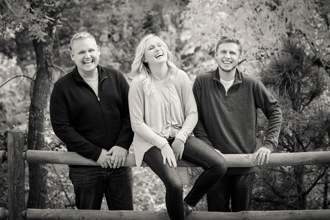 Photograph from a photo session of 3 siblings all laughing and connecting.  The image was taken in the Poudre Canyon at Gateway Natural Area