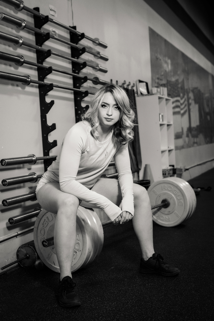 Business branding portrait of an athlete sitting on a large set of free weights
