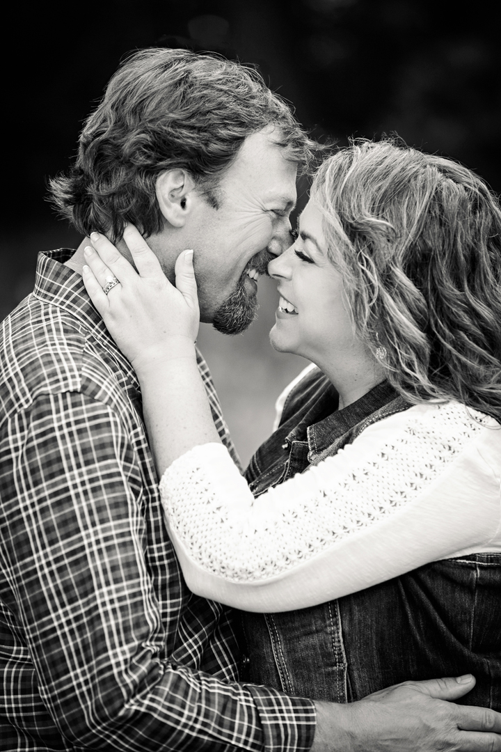 black and white portrait of a couple about to kiss while laughing