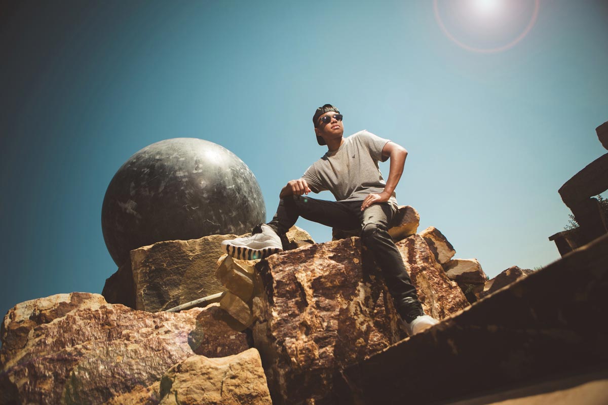 Masculine senior photo of a cool guy sitting on a rock in Fort Collins Colorado
