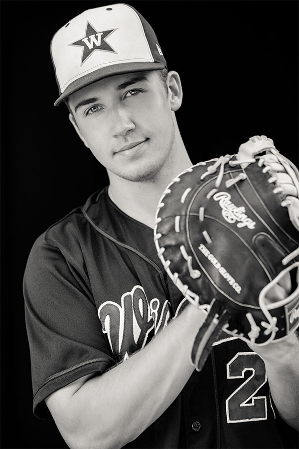 Masculine and male senior photography of a boy in his baseball gear taken in a downtown urban area of Denver Colorado.