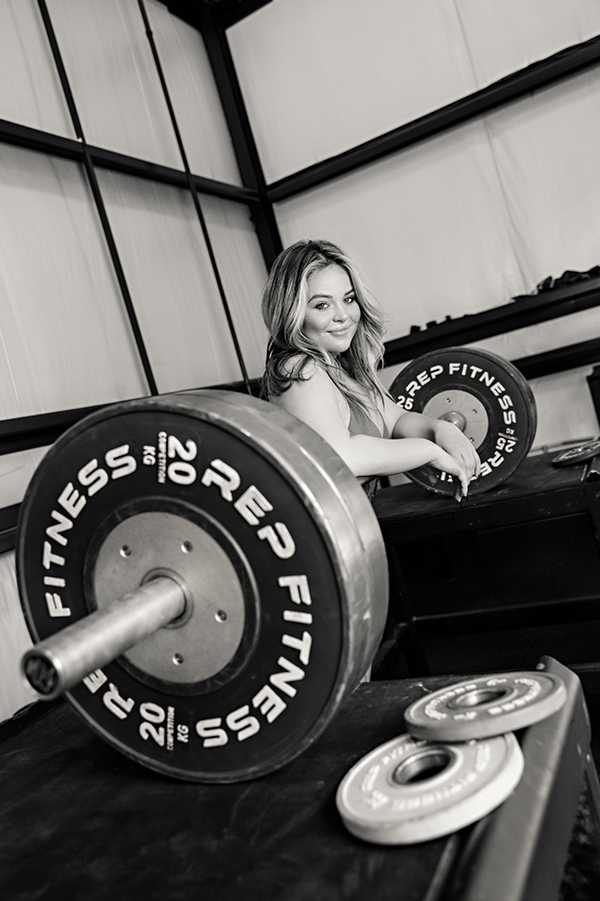 High school senior portrait of a female senior in a weightlifting gym 