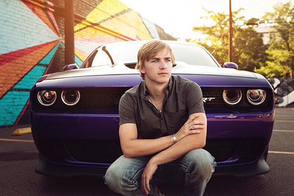 Edgy high school senior boy posing in front of his car for his senior portraits by Photography by Desirée