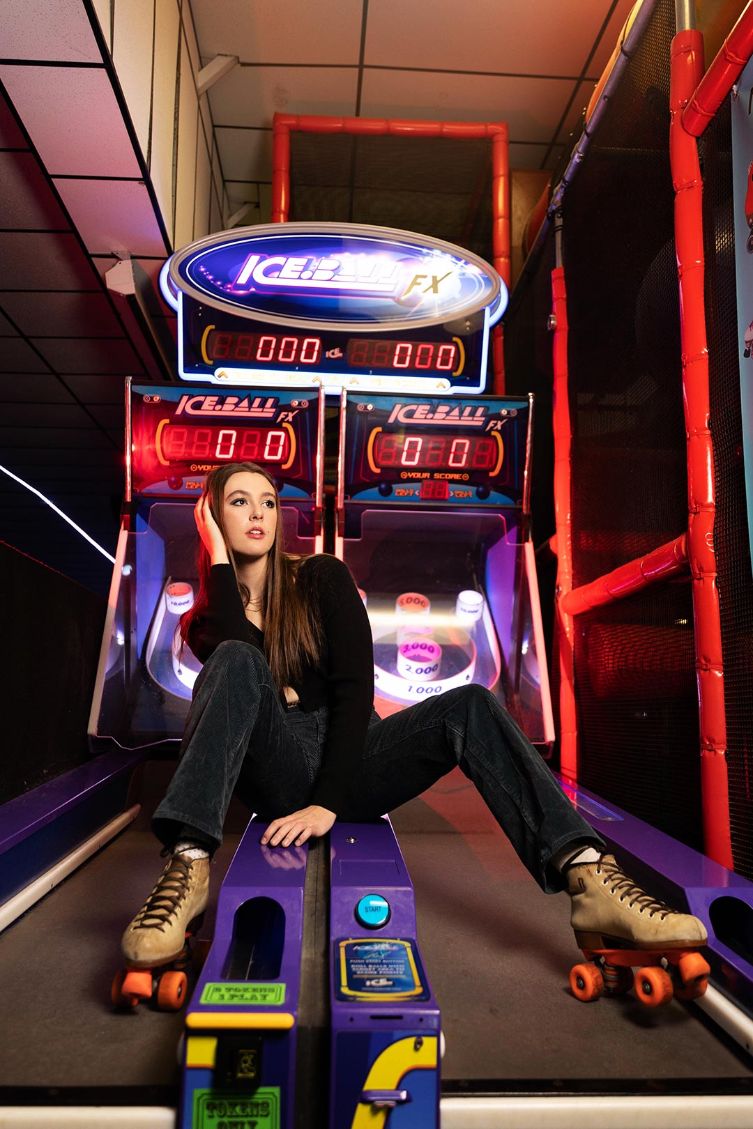 Moody retro photo of a young high school senior model on arcade game in Denver Colorado